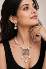 Elegant pink gemstone beaded statement necklace with pearl accents and engraved pendant worn by a woman