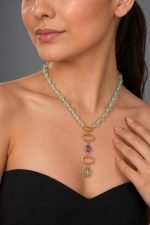 Model wearing Raga Necklace featuring mint green beaded strand with gold-plated multi-stone drop pendant in a minimal elegant style